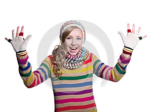 Cute cheerful teenage girl wearing colorful striped sweater, scarf, gloves and hat isolated on white background. Winter clothes.
