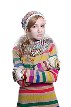 Cute cheerful teenage girl wearing colorful striped sweater, scarf, gloves and hat isolated on white background. Winter clothes.