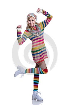 Cute cheerful teenage girl wearing colorful striped sweater, scarf, gloves, hat and white boots isolated. Winter clothes.