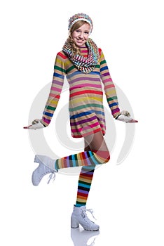Cute cheerful teenage girl wearing colorful striped sweater, scarf, gloves, hat and white boots isolated. Winter clothes.