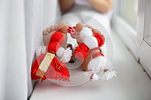 Cute child, blond boy, playing with white and red bracelet, martenitsa