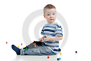 Cute child boy playing with mosaic toy