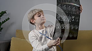 Cute child boy playing with stethoscope acting a doctor