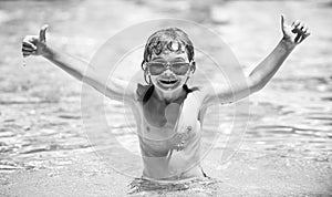 Cute child boy swim in swimming pool, summer water background with copy space. Funny kids face. Excited funny child in