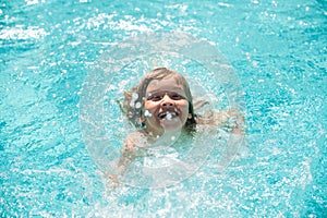 Cute child boy swim in swimming pool, summer water background with copy space. Funny kids face. Little boy playing in