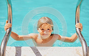 Cute child boy swim in swimming pool, summer water background with copy space. Funny kids face. Summer activities for