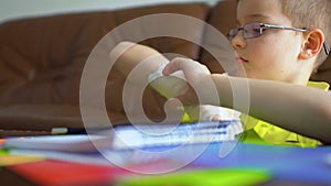 Cute child with broken hand can`t make his homework