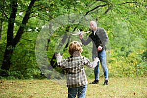 Cute child with dad play with toy plane. Father& x27;s day. Dad and baby son playing together outdoors toy airplane.