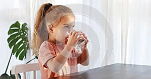 Cute child is drinking a cup of water