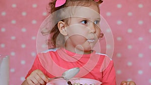 Cute child eating cereals. Little girl eating breakfast cereal with milk drink yoghurt smiling happy in the morning.