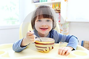 Cute child eats soup