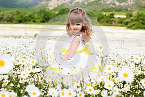Cute child girl at camomile field