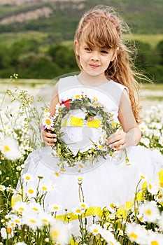 Cute child girl at camomile field