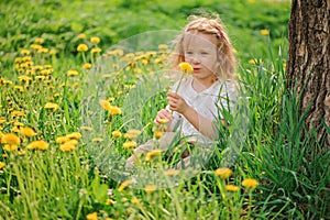 Cute child girl on dandelion flower field