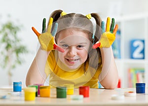 Cute child girl have fun painting her hands