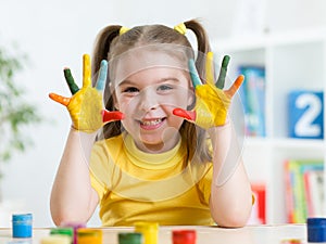 Cute child girl have fun painting her hands