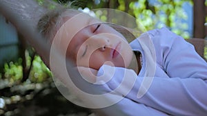 Cute child girl lying on hammock and relax at the garden.