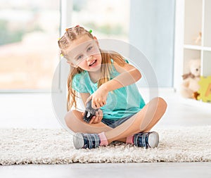 Cute child girl playing video games on console