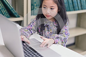 Cute child girl using computer laptop.