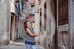 Cute child girl walking old city streets in Piran, Slovenia