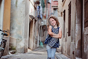 Cute child girl walking old city streets in Piran, Slovenia