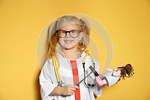 Cute child imagining herself as doctor while playing with reflex hammer and doll