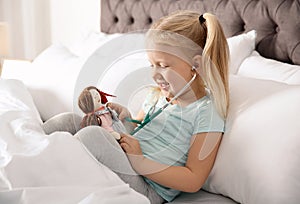 Cute child imagining herself as doctor while playing with stethoscope