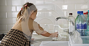 Cute child in the kitchen sorts plastic bottles while helping his mother collect garbage for recycling A little girl