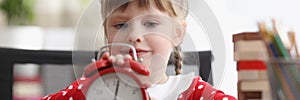 Cute child learn how to understand time and play with red retro clock