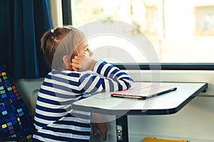 Cute child looking out the train window. Little boy is traveling on the train. Kid travels on a train