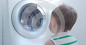Cute Child Looks Inside the Washing Machine. Cylinder Spinning Machine. Concept Laundry Washing Machine, Industry