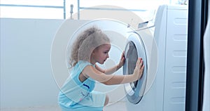 Cute Child Looks Inside the Washing Machine. Cylinder Spinning Machine. Concept Laundry Washing Machine, Industry
