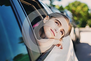 Cute child looks out the window of the car