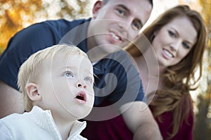 Cute Child Looks Up to Sky as Young Parents Smile