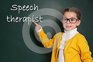 Cute child near chalkboard and text Speech Therapist