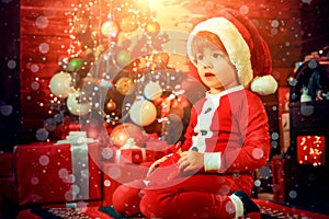 Cute child opening christmas gift. Lovely baby enjoy christmas. Santa boy little child winter celebrate at home. Boy