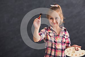 Cute child painting something with palet and brush