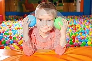 Cute child playing in ball pit