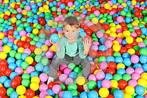 Cute child playing in ball pit