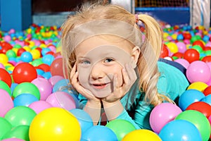 Cute child playing in ball pit