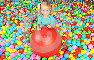 Cute child playing in ball pit