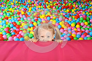 Cute child playing in ball pit