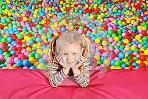 Cute child playing in ball pit