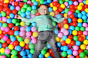Cute child playing in ball pit