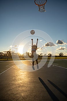 Cute child playing basketball. Cute little boy child jumping with basket ball for shot silhouette on sunset.
