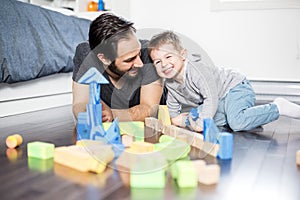 Cute child playing with color toy indoor with is dad