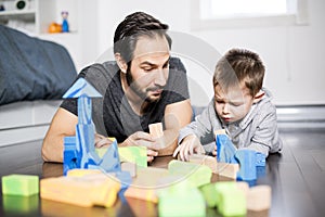 Cute child playing with color toy indoor with is dad
