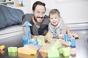 Cute child playing with color toy indoor with is dad