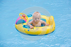 Cute child, playing with inflatable boat in pool