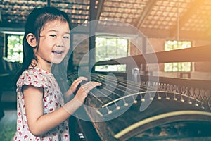 Cute child playing stringed instruments and having fun.